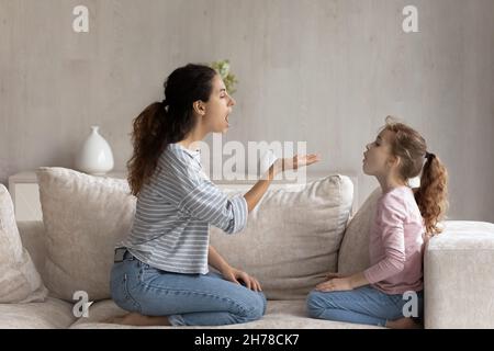 Madre preoccupante con bambino piccolo della figlia che parla, facendo le esercitazioni di discorso Foto Stock