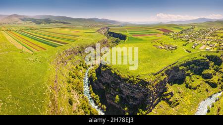 Vista aerea panoramica dei campi agricoli seminate con colture e fiume in profondo canyon. Terreno fertile e suolo erosione concetto Foto Stock