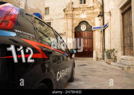 Auto Carabinieri con il numero di emergenza 112 in primo piano e sullo sfondo la stazione di polizia di Monopoli (Puglia-Italia) Foto Stock