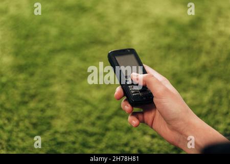 La ragazza tiene un vecchio telefono a bottone in mano Foto Stock