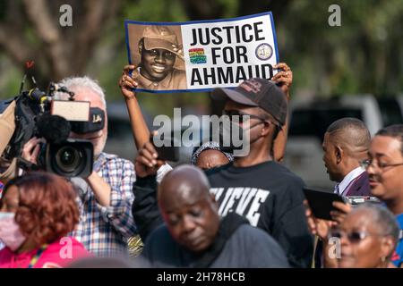 Un protestore detiene un segno che chiede la giustizia per Ahmaud Arbery come 500 pastori neri e sostenitori riuniti al di fuori del Glynn County Courthouse 18 novembre 2021 a Brunswick, Georgia. Il processo degli imputati Greg McMichael, Travis McMichael, e un vicino, William 'Roddie' Bryan continuò all'interno del tribunale. Foto Stock