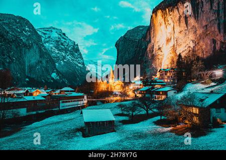 incredibile villaggio turistico alpino di notte in inverno con famoso chiesa e cascata di Staubbach Lauterbrunnen Svizzera Europa Foto Stock