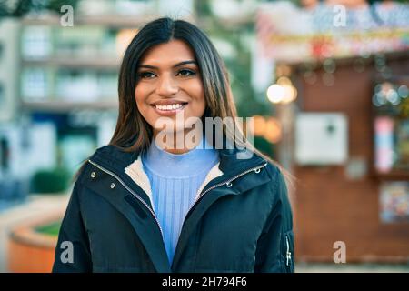 Bella donna ispanica sorridente confidente in città Foto Stock