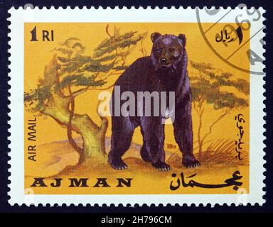 AJMAN - CIRCA 1969: Un francobollo stampato in Ajman mostra Brown Bear, Ursus arctos, Animal, circa 1969 Foto Stock