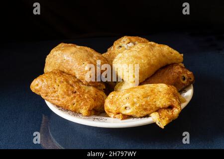 Pancake con ripieno in un piatto sul tavolo con un riflesso. Cibo su sfondo nero Foto Stock