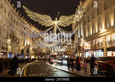 LONDRA, UK - 20 NOVEMBRE 2021: Viste lungo Regent Street a Londra a Natale mostrando le decorazioni e fuori dei negozi. Le persone possono essere viste all'esterno. Foto Stock