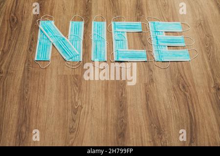 Capital Letters Nice composto da maschere Mediche Blu su a. Marrone sfondo Foto Stock