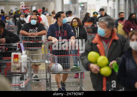La gente che indossa le maschere facciali è veduto lo shopping ad un deposito di Costco.prima della festa di ringraziamento, gli acquirenti hanno fatto una corsa dell'ultimo minuto ai depositi della drogheria per le forniture di ringraziamento. Foto Stock