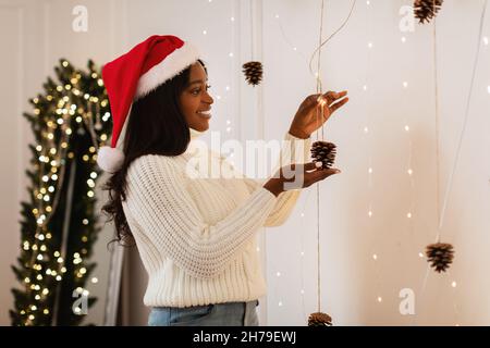 Ritratto di felice afroamericana signora decorazione appartamento per Natale Foto Stock