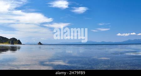 Serenity Morning view of low marea with mirror reflection Sky on surface of water..Kunashir Island of Kuril Chain. Russia Foto Stock