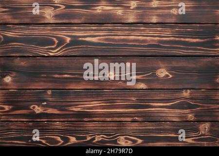 Marrone scuro spazzolato legno bruciato tavole sfondo Foto Stock