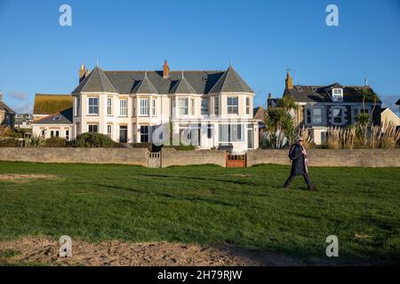 Perranporth,Cornovaglia,UK, 21 novembre 2021,Una casa che domina la spiaggia di Perranporth nel tardo pomeriggio sole autunnale si prevede di essere lo stesso domani con un alto di soli 9C. Il Watering Hole è l'unico bar sulla spiaggia del Regno Unito con ombrelloni in stile tropicale ed è un luogo famoso per ammirare il tramonto. Credit: Keith Larby/Alamy Live News Foto Stock