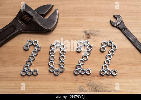 Anno nuovo 2022 i numeri sono rivestiti con dadi metallici su un tavolo di legno, due vecchie chiavi giacciono accanto a loro. Vista dall'alto. Foto Stock