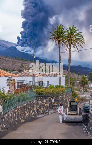 LOS LLANOS DE ARIANE, SPAGNA NOVEMBRE 10.2021: Uomo che guarda all'eruzione del vulcano Cumbre Vieja dopo aver pulito la strada dalla cenere all'isola delle Canarie Foto Stock