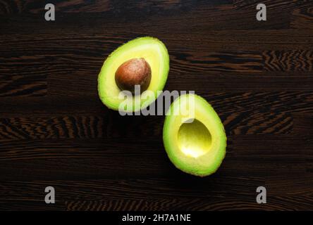 Metà avocado su tavola di legno Foto Stock