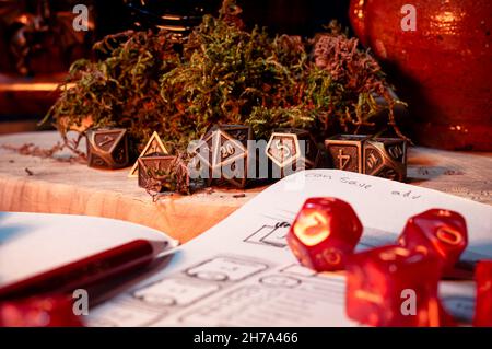 Immagine di un set di dadi RPG metallici su un asse di legno Foto Stock