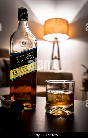 BANGALORE, INDIA - 07 maggio 2021: Un colpo verticale di una bottiglia nera di scotch dell'etichetta del Johnnie Walker e un vetro riempito del whiskey a Bangalore, India Foto Stock