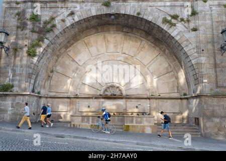 La gente sale sul ripido pendio passando Fonte Monumental de Mouzinho da Silveira nel quartiere storico di Ribeira a Porto, Portogallo. Foto Stock