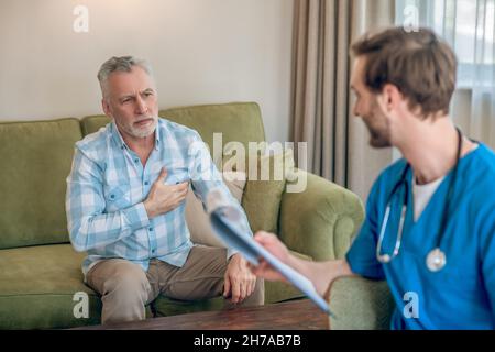 Paziente maschio che discute il suo problema di cuore con un medico Foto Stock