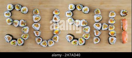 Rotoli di sushi disposti su un asse di legno per spiegare 'Sushi' Foto Stock