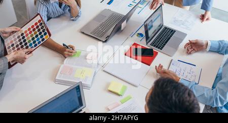 Colleghi che collaborano e condividono idee alla scrivania in ufficio Foto Stock