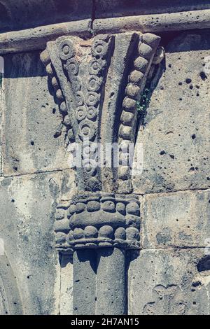 Dettagli e schemi ravvicinati scolpiti in pietra sulla facciata di un antico monastero o chiesa in Armenia Foto Stock