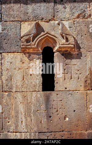 Dettagli e schemi ravvicinati scolpiti in pietra sulla facciata di un antico monastero o chiesa in Armenia Foto Stock