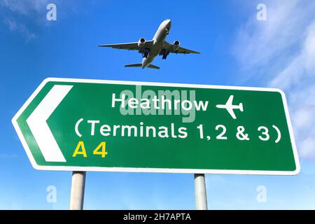 Aereo che vola sopra il cartello stradale del terminal dell'aeroporto di Heathrow, Cranford, London Borough of Hounslow, Greater London, England, United Kingdom Foto Stock