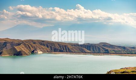 Vista su una gola di montagna con un serbatoio d'acqua di colore turchese brillante. Il fiume Azat in Armenia e montagne aride sullo sfondo. Foto Stock