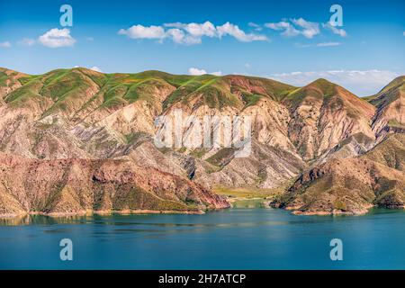 Vista di una valle di montagna con un bacino di Azat con un colore turchese brillante in Armenia e terreno arido sullo sfondo. Foto Stock