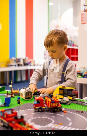 Little boy gioca a colori Lego set sul tavolo. Formazione e sviluppo  precoce Foto stock - Alamy