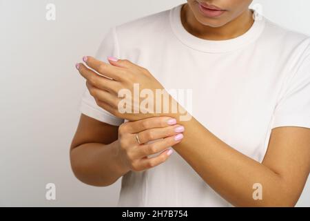 La donna infelice tocca il polso nel dolore dall'uso del computer, soffre di sindrome da ufficio, mal di tunnel carpale Foto Stock