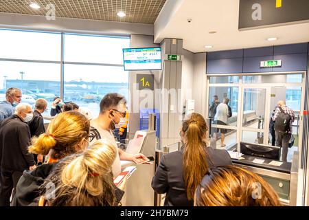 I passeggeri in maschera facciale vengono controllati per i loro biglietti e passaporti presso il Gate 1A per imbarcarsi sul volo in aeroporto di Domodedovo, DME, Mosca, Russia Foto Stock