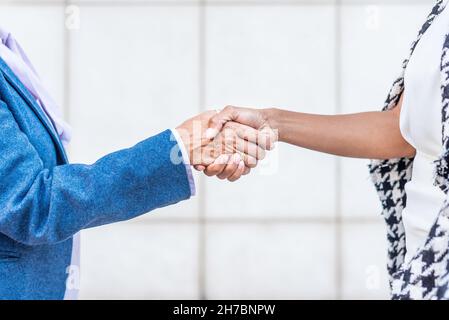 primo piano di stretta di mano tra due persone di etnie diverse Foto Stock