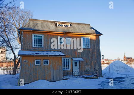 Umea, Norrland Svezia - 2 marzo 2021: Una delle ultime vecchie case sul fiume Foto Stock