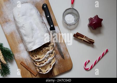 Piatto di pane di Natale con cannella, cannella e candela su sfondo bianco Foto Stock