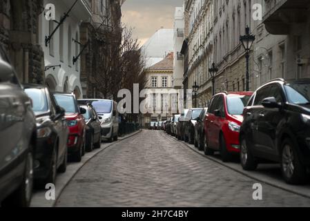 Auto parcheggiate in linea su entrambi i lati di via Veres Pálné a Budapest Foto Stock