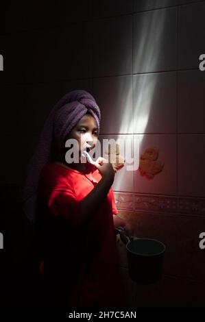 Bambino indonesiano che le spazzolava i denti in bagno. Foto Stock