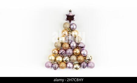 Albero di Natale fatto di sfere di vetro di Natale in colori di tendenza 2022. Boccali di natale rosa Pacifico e viola velluto a forma di tre di Natale Foto Stock