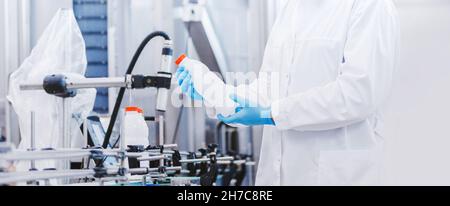 Banner concept food industry. Il lavoratore che ispeziona la bottiglia della linea di produzione in una fabbrica di birra o di latte. Foto Stock