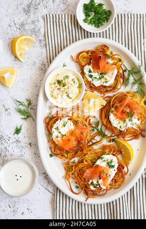 Patate rosolate con salmone affumicato, aneto e salsa bianca. Frittelle di patate, deliziose frittelle di verdure. Polpettine di patate o crocchette di patate. Hashe croccante Foto Stock