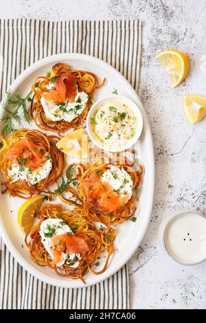 Patate rosolate con salmone affumicato, aneto e salsa bianca. Frittelle di patate, deliziose frittelle di verdure. Polpettine di patate o crocchette di patate. Hashe croccante Foto Stock