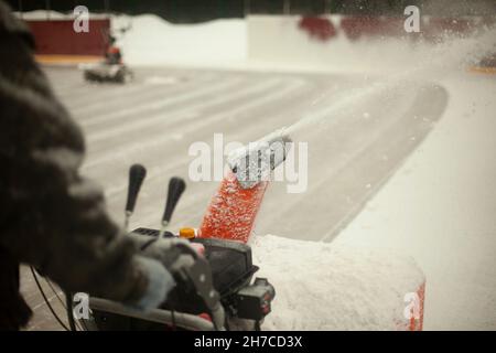 Rimozione della neve con l'aiuto della tecnologia. Spazzaneve in funzione. Preparazione del ghiaccio per il pattinaggio. Dettagli di pulizia dello stadio da fresco precipizio Foto Stock