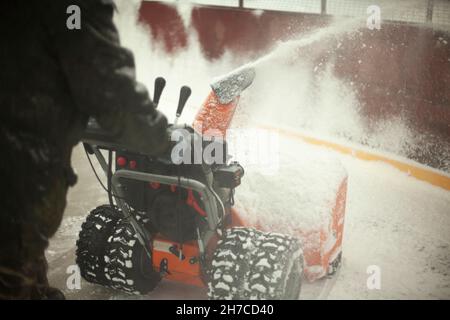 Rimozione della neve con l'aiuto della tecnologia. Spazzaneve in funzione. Preparazione del ghiaccio per il pattinaggio. Dettagli di pulizia dello stadio da fresco precipizio Foto Stock