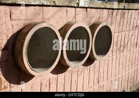 Tre tubi rossi che escono dal muro Foto Stock