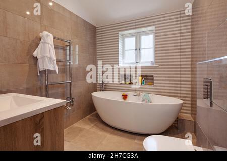 Lawshall, Suffolk, Inghilterra - Maggio 29 2020: Luminosa suite completamente piastrellata con bagno moderno e alla moda. Foto Stock