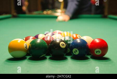 Palline da biliardo sono nel gioco. Il giocatore di biliardo si prepara a colpire Foto Stock