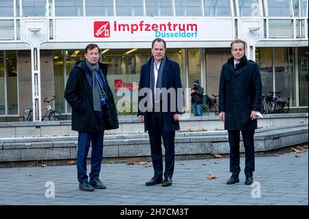 Duesseldorf, Germania. 23 novembre 2021. Burkhard Hintzsche (l-r), direttore della città di Düsseldorf, Stephan Keller, sindaco di Düsseldorf, David von der Lieth, capo dei vigili del fuoco di Düsseldorf, si trova di fronte al centro di vaccinazione di recente apertura. A causa dell'aumento della domanda, la città di Düsseldorf sta espandendo le capacità di vaccinazione e sta aprendo un nuovo centro di vaccinazione nell'ex biblioteca centrale della stazione ferroviaria principale. Credit: Malté Krudewig/dpa/Alamy Live News Foto Stock