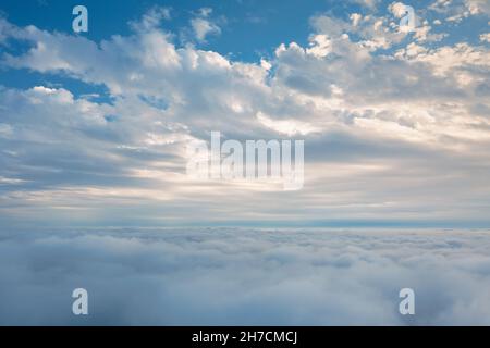 Cielo cielo sopra le nuvole - vista spettacolare dal pozzetto dell'aeroplano. Nuvole sognanti bianche e soffici nell'aria sopra le nuvole. Foto Stock