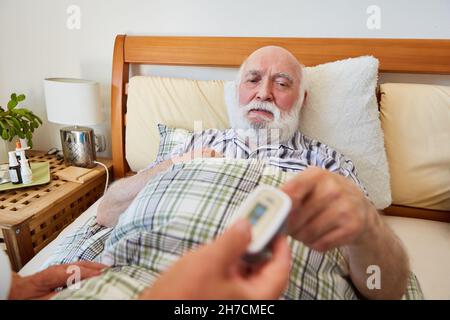 Il personale infermieristico controlla il polso del paziente a casa con il pulsossimetro Foto Stock